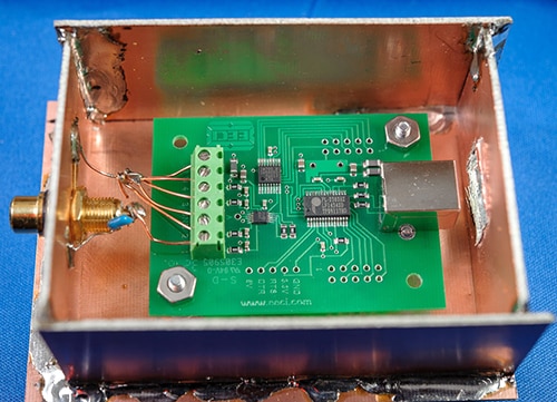 Shield (with cover removed) around a small pc board ภาพโล่ (ถอดฝาครอบออก) รอบ ๆ บอร์ดพีซีขนาดเล็ก