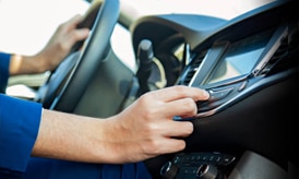 A driver operating a car built in radio.