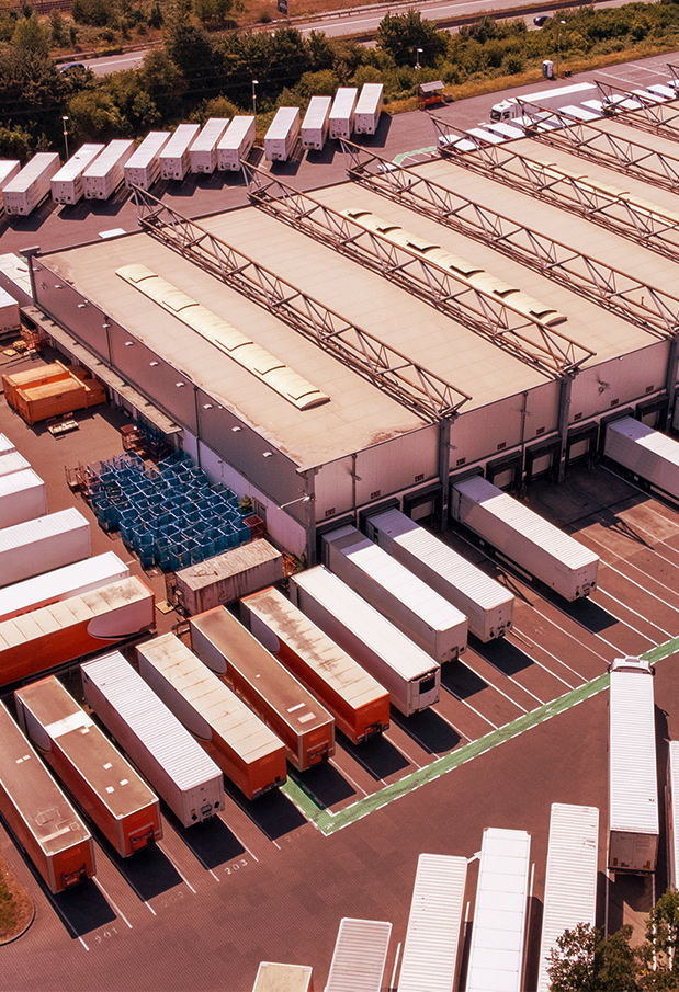 Et stort antall traktortilhengere parkert på et lager