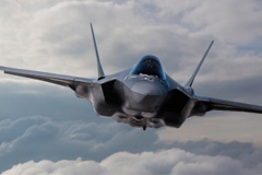Front view of a fighter jet flying over the clouds